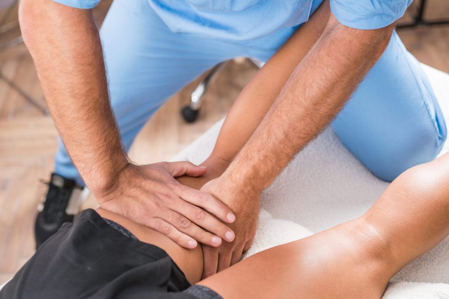 Physical therapy. Hands of physical therapist treating muscles of a female athlete